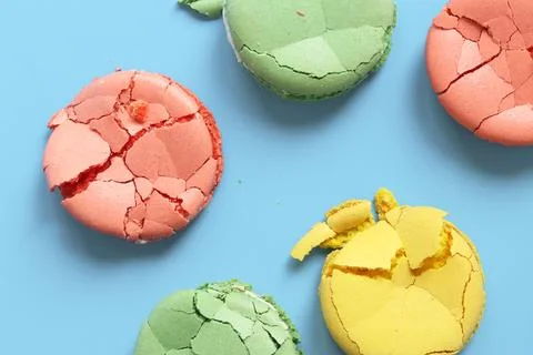 Crumpled macarons, flat lay. Broken macaron on blue background Fotos Stock