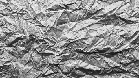 Crumpled metallic foil texture forms a dramatic abstract pattern featuring .. Stock Photos