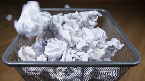 Crumpled paper documents fly into the trash bin, overflowing the basket Video stock 130946406