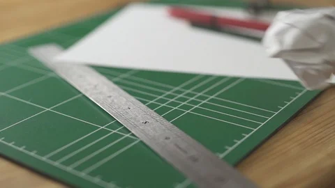 Crumpled papers fly in frame with arts and crafts objects on table Stock Footage 109044441