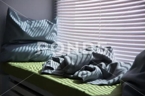 Crumpled pillow and a blanket on the windowsill Stock Photos