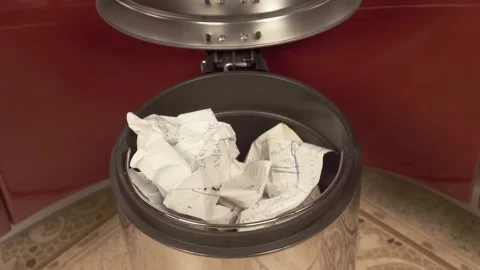 Crumpled sheet of paper that turned out to be unnecessary flies into a trash can Stock Footage 297824992