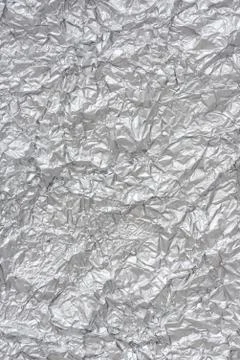 Crumpled silver foil close-up. Textured background in cold winter colors Stock Photos