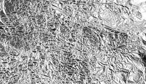 Crumpled silver foil texture with shiny metallic surface creates an abstrac.. Stock Photos