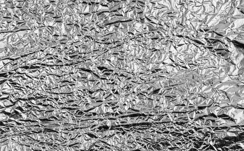 Crumpled silver foil texture with shiny metallic surface creates an abstrac.. Stock Photos