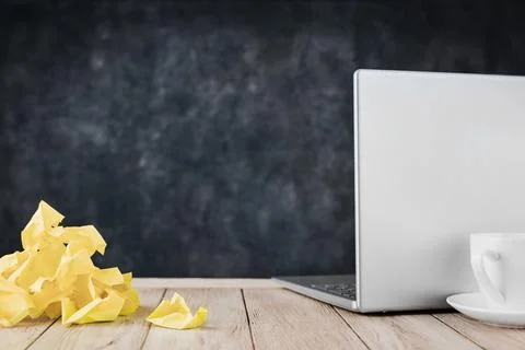 Crumpled sticky notes sit beside a closed laptop and coffee with copy space Stock Photos