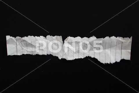 Photograph: Crumpled torn paper piece isolated on a black background ...