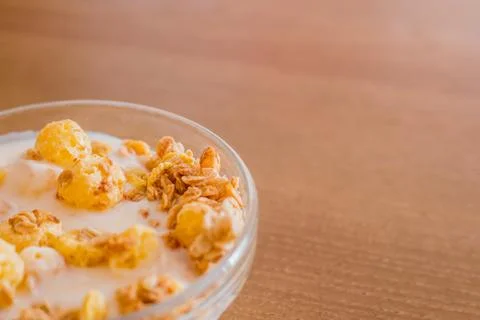 Crunches and corn flakes with yogurt in a transparent glass bowl for cooking  Stock-Fotos