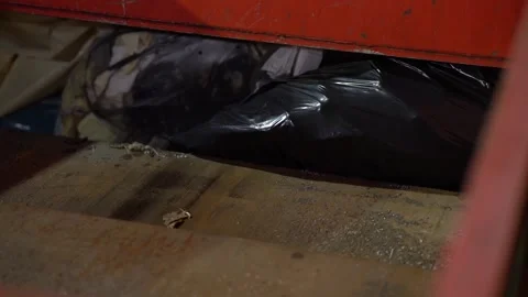 Crush trash in a red trash compactor at night Video stock 203855857