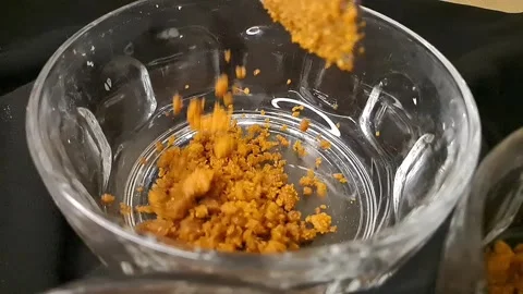 Crushed biscuits falling into a shiny mirror bowl Stock Footage 316467582