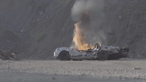Crushed car on fire Stock Footage 266882815