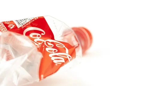Crushed Coca-Cola plastic bottle showing recycling symbol Stock Photos