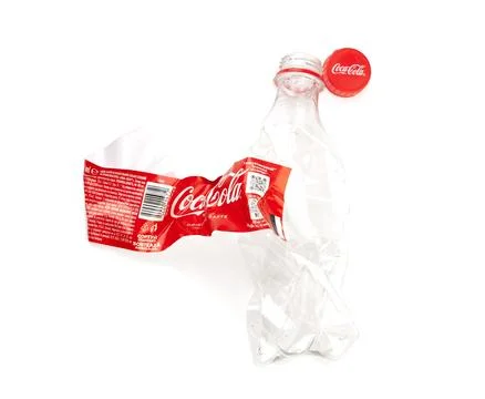 Crushed Coca-Cola plastic bottle symbolizing pollution and recycling Stock Photos