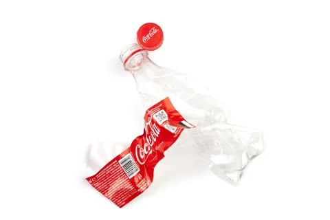 Crushed Coca-Cola plastic bottle and cap on a white background Stock Photos