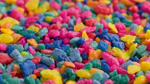 Crushed colored stones on flat surface, slowly spinning, loopable closeup Stock Footage 173499973