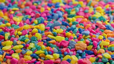 Crushed colored stones on flat surface, slowly spinning, loopable closeup Stock Footage 173652943