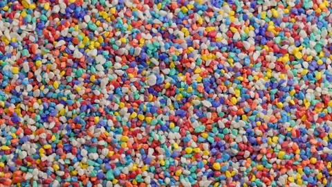 Crushed colored stones on flat surface, slowly spinning, loopable closeup Video stock 176259851