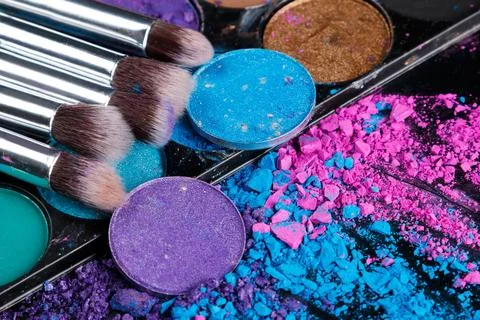 Crushed eyeshadows and make-up brushes Stock Photos