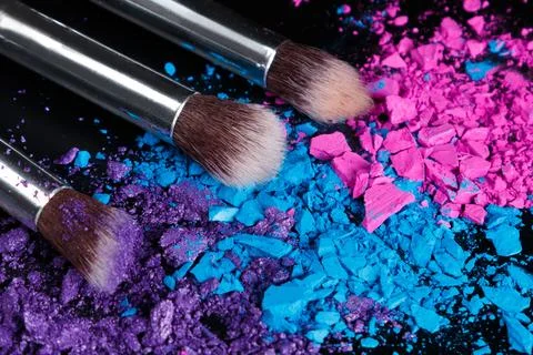 Crushed eyeshadows and make-up brushes Stock Photos