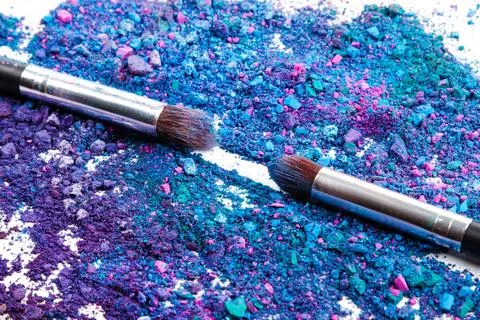 Crushed eyeshadows and make-up brushes Stock Photos