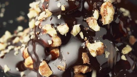 Crushed nuts fall on top of chocolate covered walnut dessert, slow motion. Stock Footage 144485465