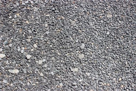 Crushed old asphalt pavement. Small gray-black pebbles. Stock Photos