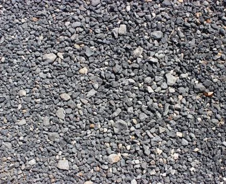 Crushed old asphalt pavement. Small gray-black pebbles. Stock Photos