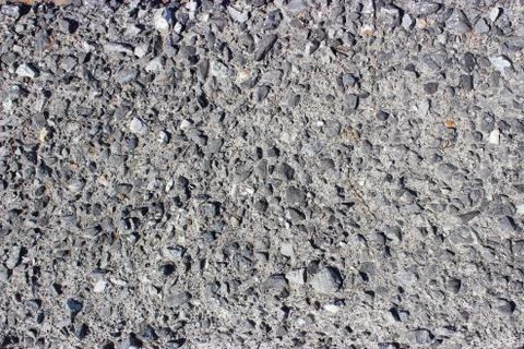 Crushed old asphalt pavement. Small gray-black pebbles. Stock Photos