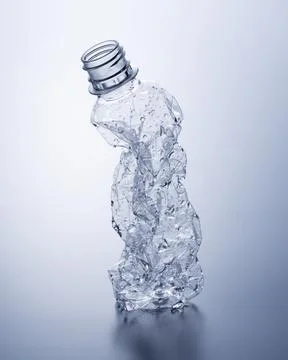 A crushed plastic bottle on a gray background. Stock Photos