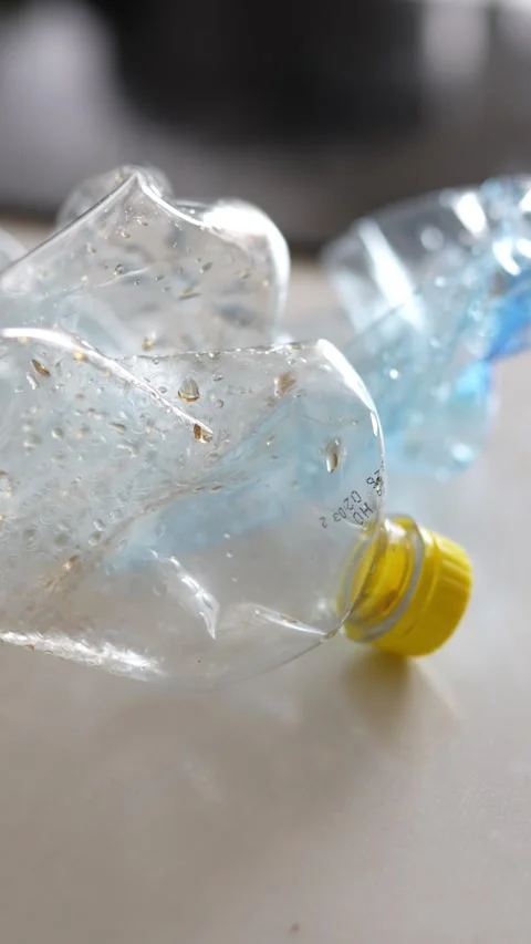 Crushed plastic water bottle lying inside a white plastic bag Stock Footage 332580359