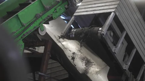 Crushed rubber chunks fall into deep metallic chute Vídeo Stock 314640139