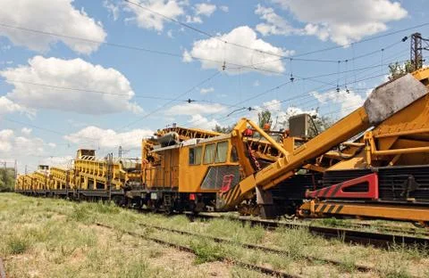 Crushed stone install construction machine on railway. Stock Photos