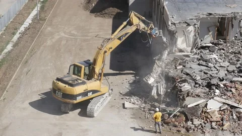Crusher at work  while a worker uses a water jet to prevent dust Stock-Footage 196123055