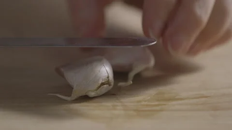 Crushing and peeling two cloves of garlic Stock Footage 64047244
