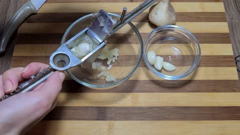 Crushing garlic to add to the dish. Stock Footage 157396590