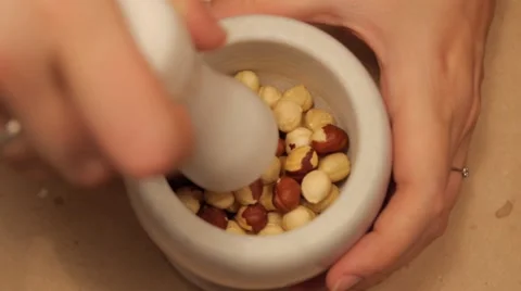 Crushing hazelnuts in a mortar in slow motion Stock Footage 49075708