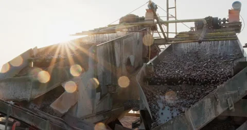 Crushing screening plant at sunset. Rocks and sand move up on conveyor line to Stock Footage 292304088