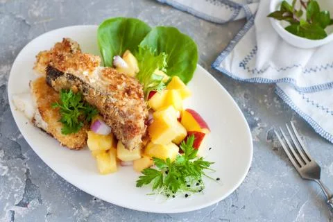 Crusted cod with peach and pineapple salsa Stock Photos