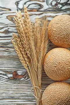 Crusty bread bundle of rye ears on vintage wooden surface 스톡 사진