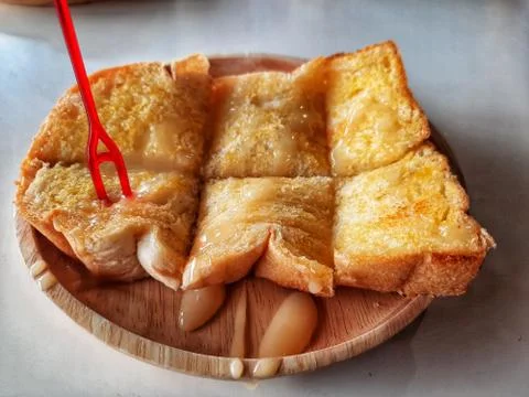Crusty Bread Toast Slice with caramel On wooden plate Background Stock Photos