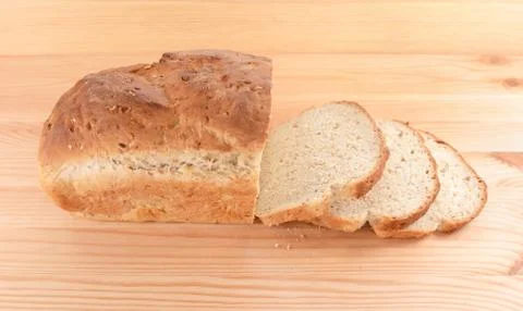 Crusty loaf of fresh bread and three slices Stock Photos
