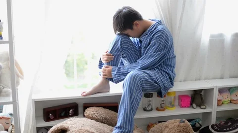 Cry little boy sits alone front of the window Stock Footage 96331397