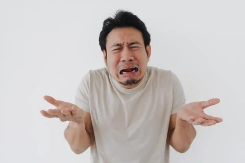 Crying Asian man expressing deep frustration and helplessness with open han.. Stock Photos