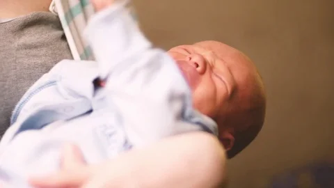 Crying baby while mother caressing with kiss 4K. Man and woman take care of own Stock Footage 73533761