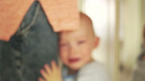 Crying boy standing next to her mother. Toddler wants to mums arms. Child Stock Footage 121054672