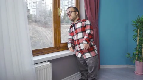 Crying dwarf man looking out the window at his house. Stock Footage 230977706