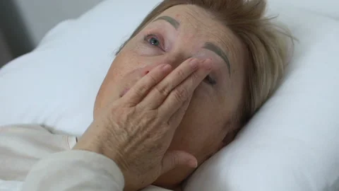Crying elderly lady lying in bed at home, depression, life and health problems Stock Footage 105874379