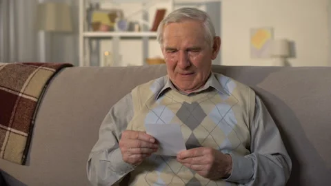 Crying elderly man looking at photo, remembering old lost friend, memories Stock Footage