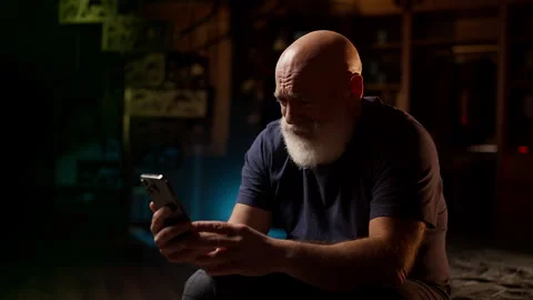 Crying middle-aged man looks at photo on phone, struggling with loneliness Stock Footage 342520622