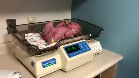 Crying newborn on scales Stock Footage 132211002